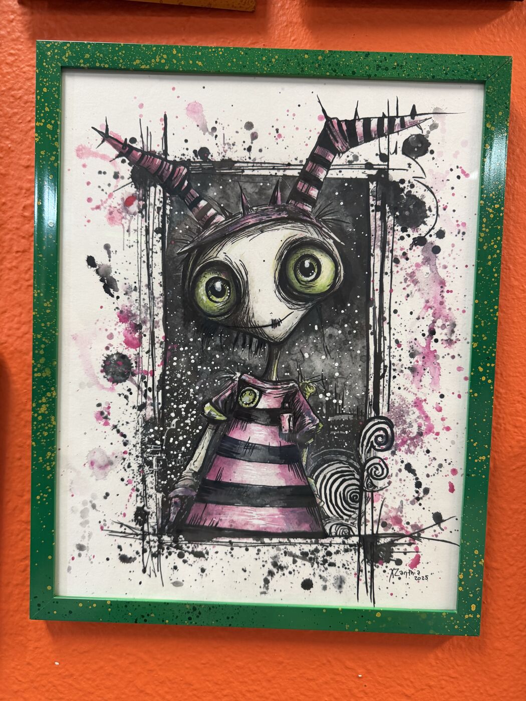 Framed creepy-cute watercolor creature by XZanthia, photographed against her painted gallery wall (piece 8 of 24)