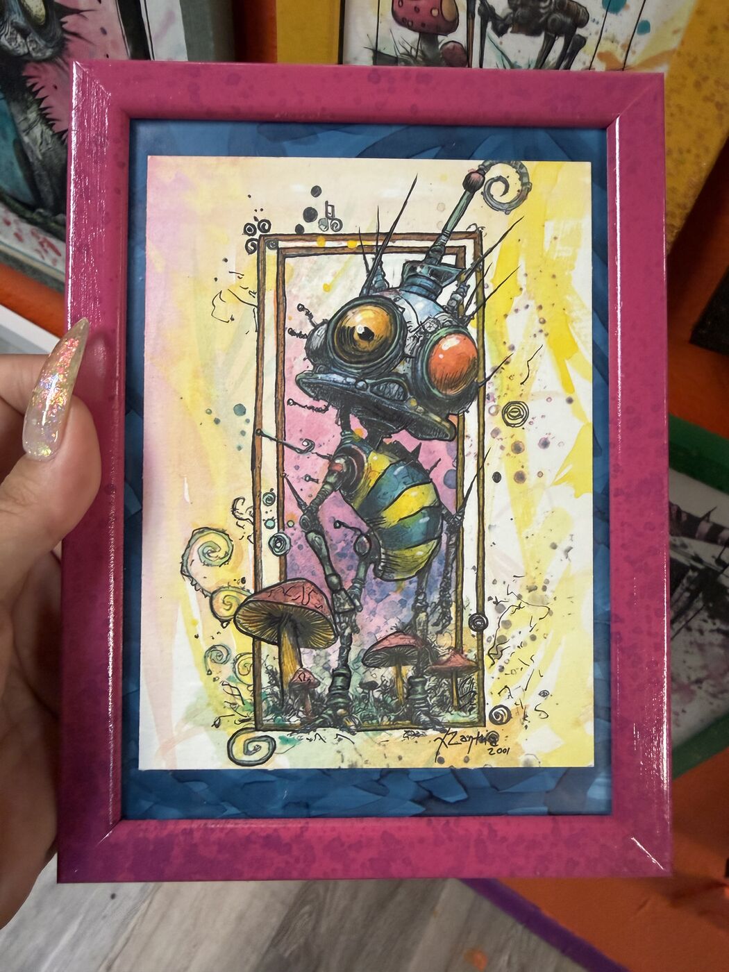 Framed creepy-cute watercolor creature by XZanthia, photographed against her painted gallery wall (piece 10 of 24)