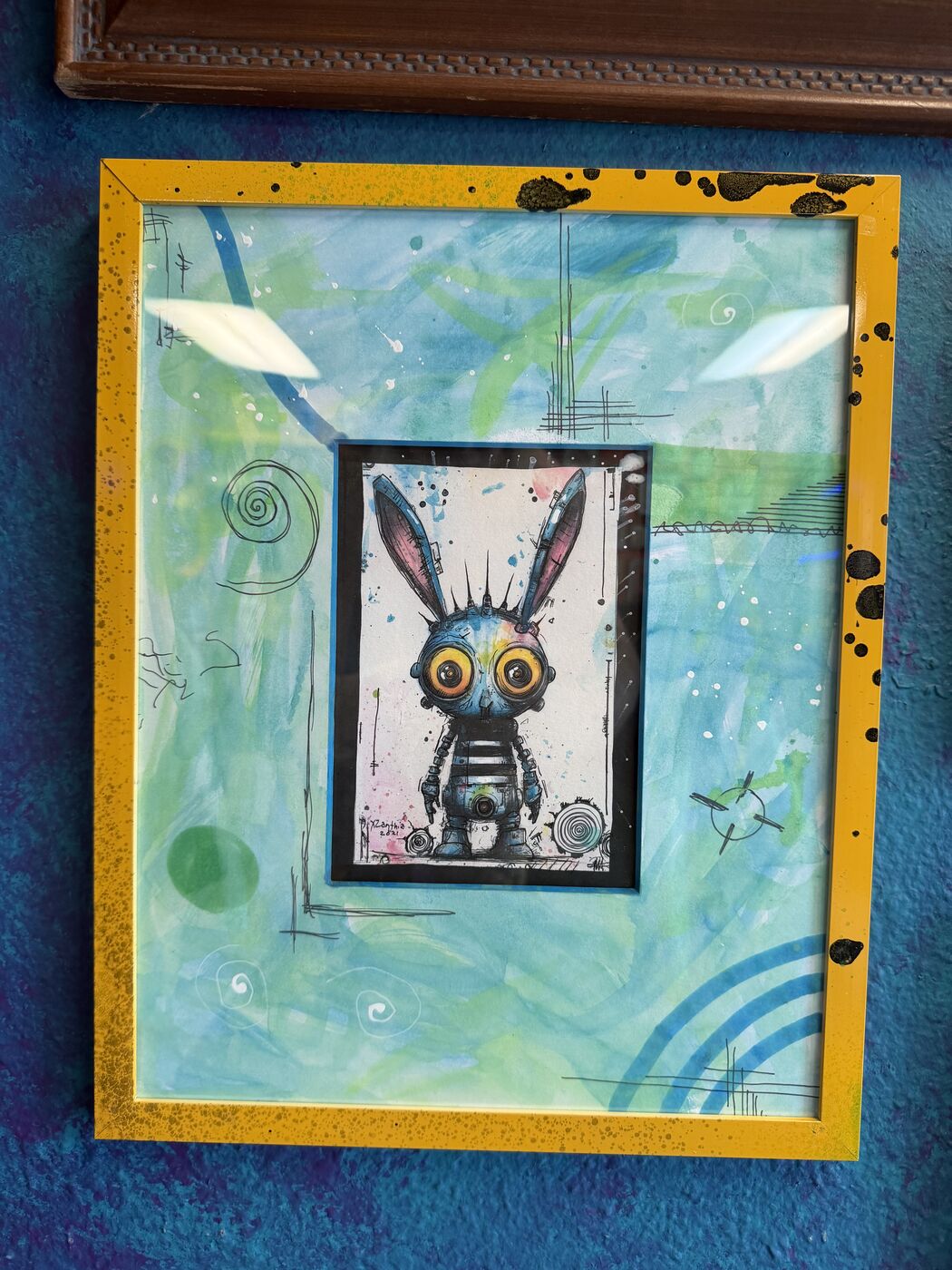 Framed creepy-cute watercolor creature by XZanthia, photographed against her painted gallery wall (piece 15 of 24)