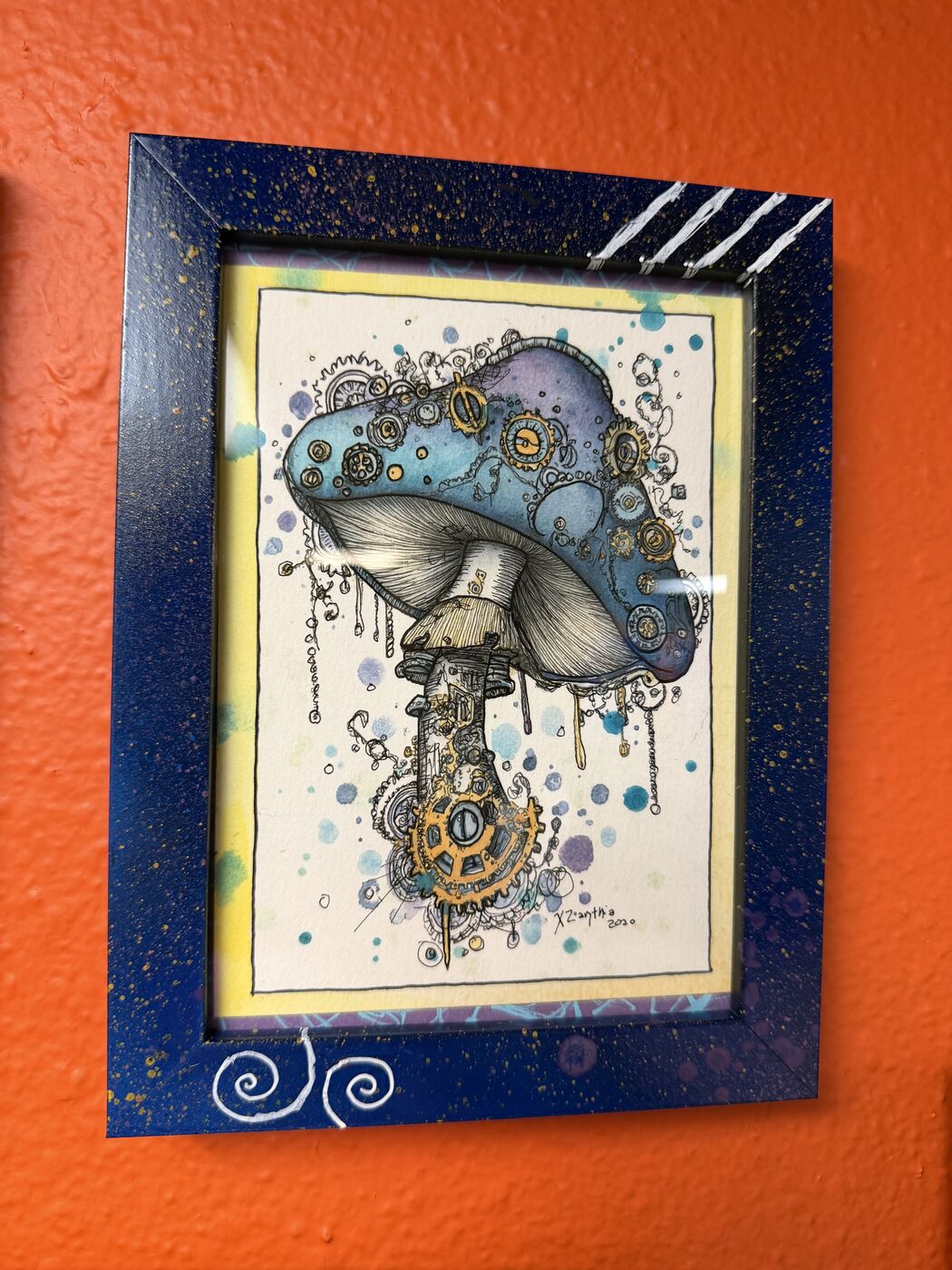 Framed creepy-cute watercolor creature by XZanthia, photographed against her painted gallery wall (piece 16 of 24)